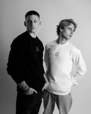 Two people wearing OUT OF MOOD  black and white SIMPL crewnecks against a gray background. Hungarian streetwear brand.
